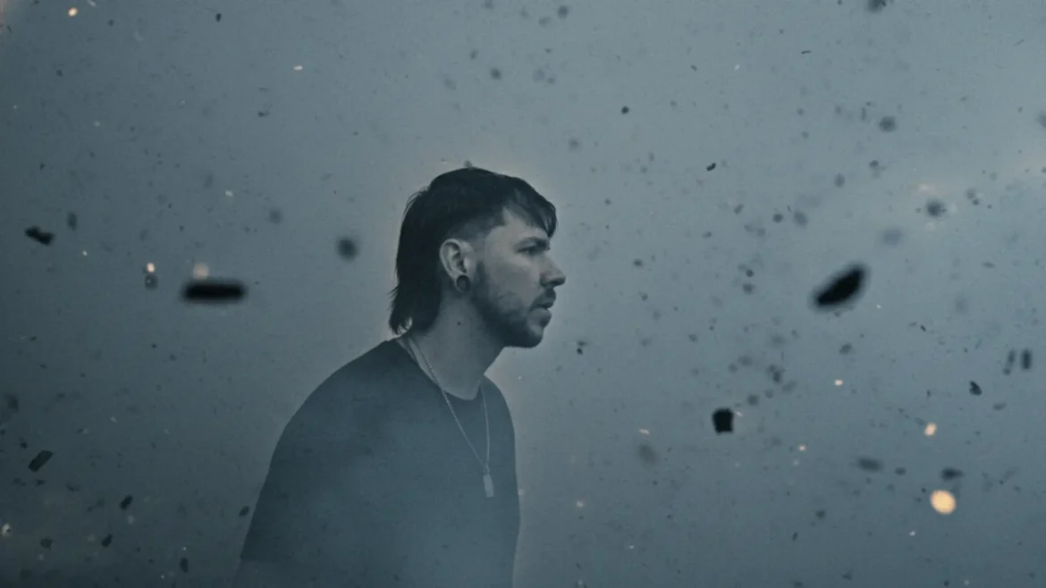 Seide stands in stormy chaos as debris floats around him, symbolizing struggle and strength.