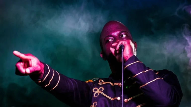 New Lewi performing live on stage with purple lighting.