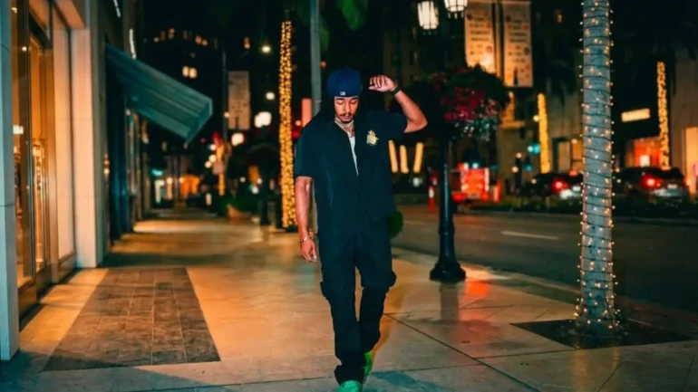 WAVVEEE walking on city street at night wearing neon green shoes.