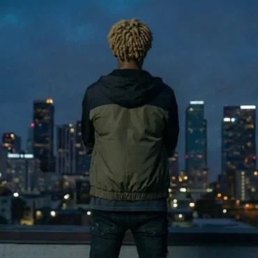kvs standing on a rooftop at night with city skyline background
