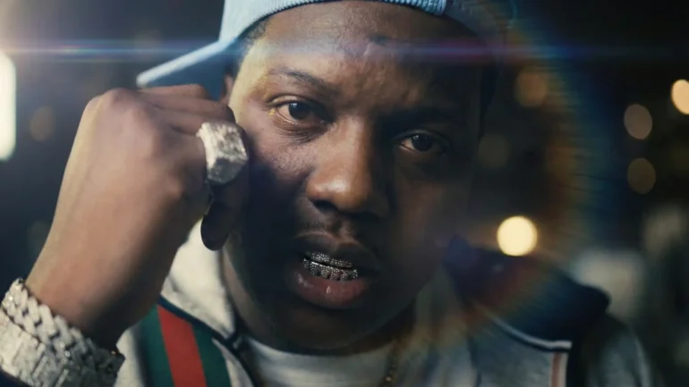 MacBoy Dero close-up wearing diamond grills and chains with a Gucci jacket.