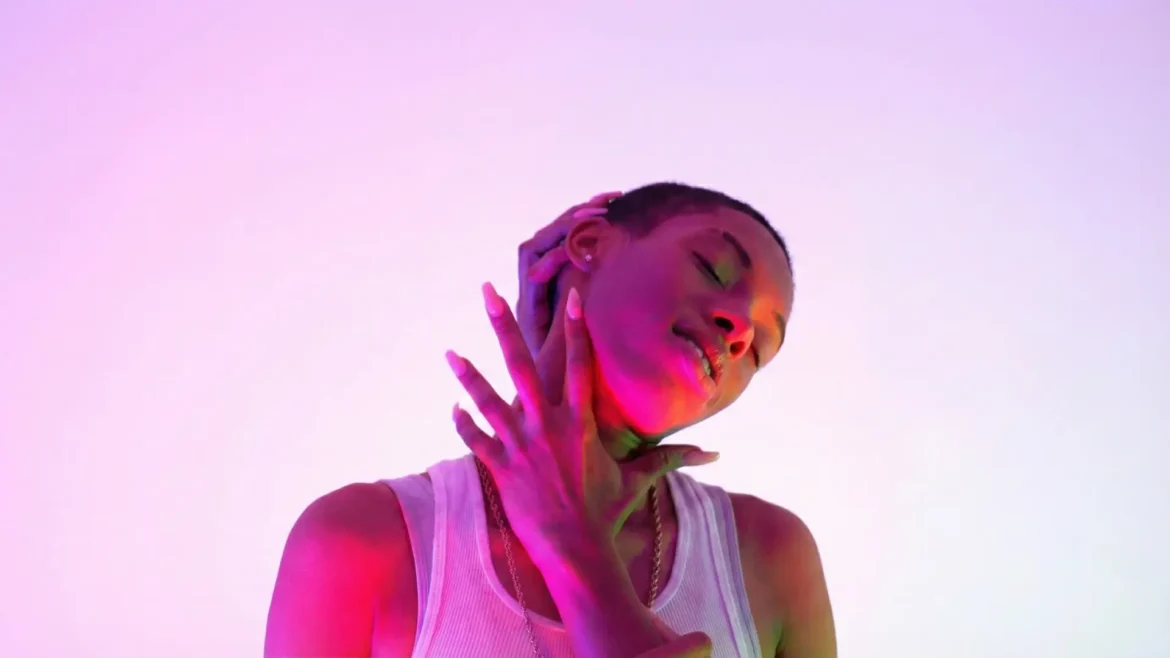Nazzy the Mic posing in purple and pink studio lighting.