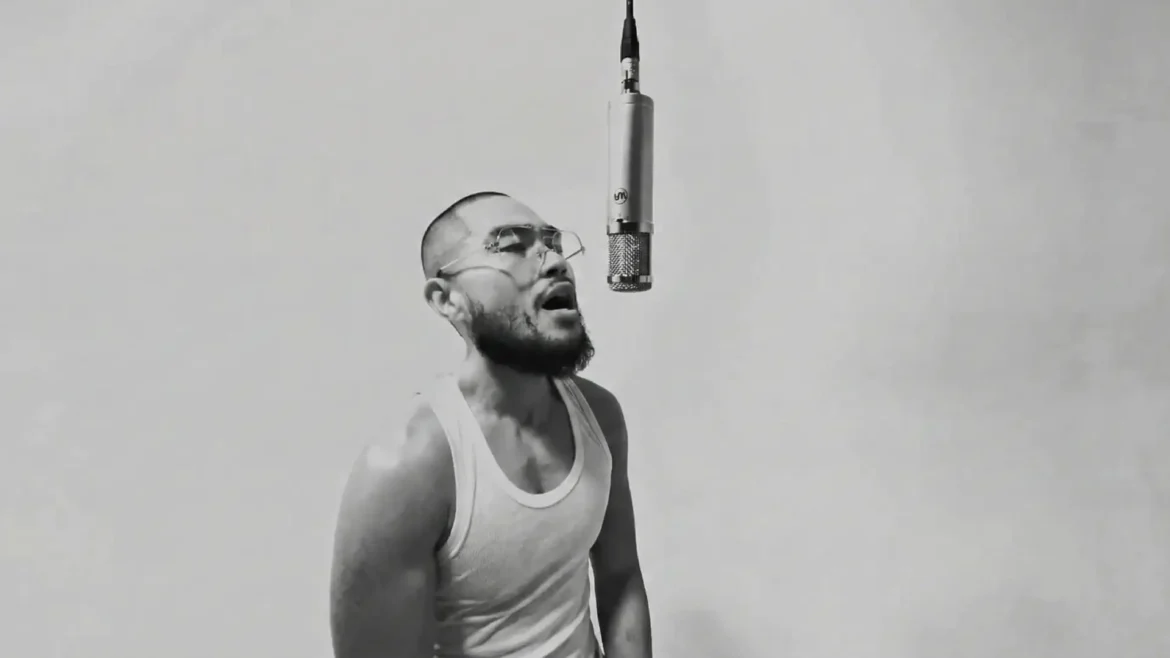 Russell Evan rapping into a hanging microphone in black and white.