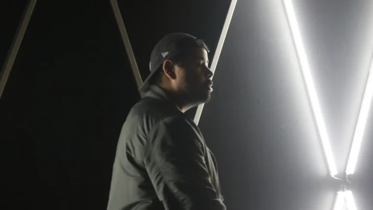 Rapper Kevin King in side profile with neon lights.