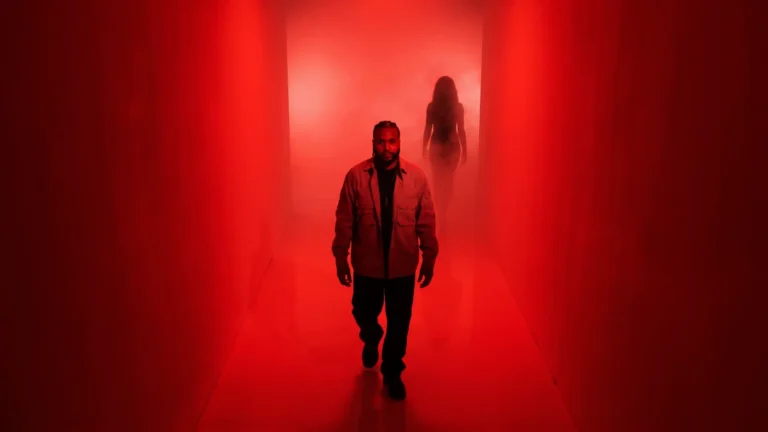 Rodney Hazard walking down a red-lit corridor with a woman's silhouette behind him.