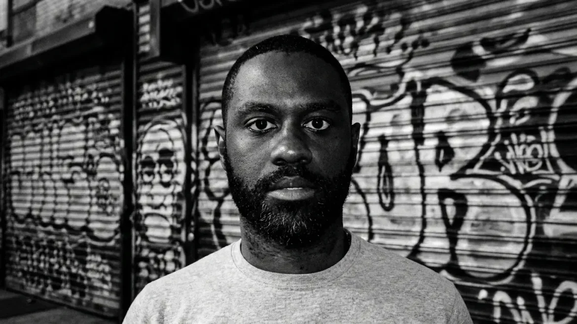Kevin Anglade, black and white portrait against a graffiti-covered roller shutter, promoting "BRANDED"