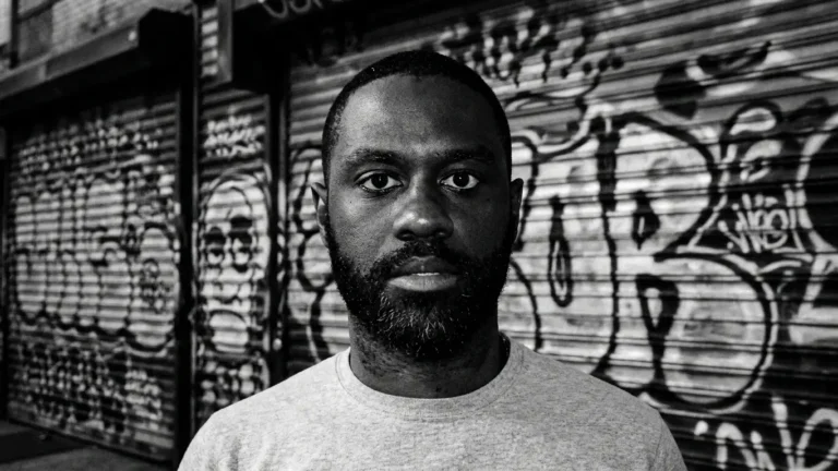 Kevin Anglade, black and white portrait against a graffiti-covered roller shutter, promoting "BRANDED"