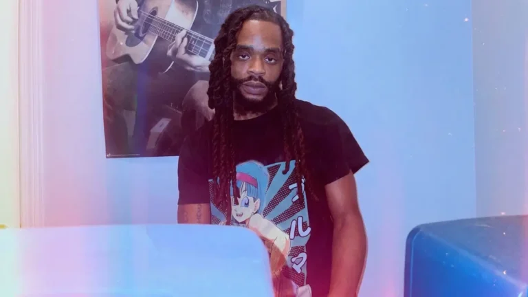 Piff Loonez, New Jersey rapper, standing in a blue-lit room wearing a black graphic tee, looking directly at camera